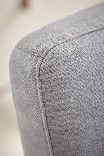 Rückenlehne eines grauen Stuhls.