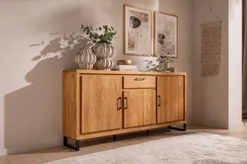 Sideboard aus hellem Holz mit schwarzen Kufen und schwarzen Metallgriffen, auf dem mehrere Vasen in grau und Beige stehen und Bücher liegen.