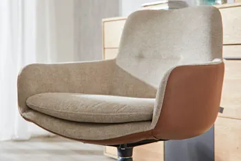 Moderner Armlehnstuhl mit beigem Stoff innen und Leder in Cognac außen.