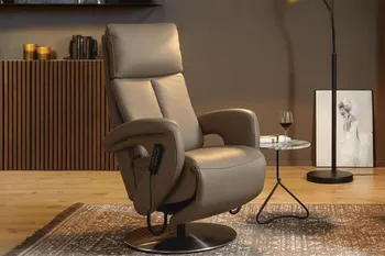 Grauer Relaxsessel mit hoher Rückenlehne in einem gemütlichen Raum mit Beleuchtung.