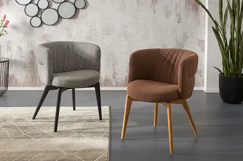 Grauer Esszimmerstuh mit runder Lehne und schwarzem Gestell neben einem braunen Esszimmerstuhl mit runder Lehne und Holzgestell.