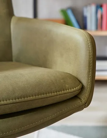 Sitzfläche eines grünen Leder Armlehnstuhls im Detail.