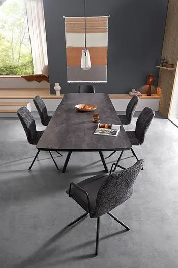 Modernes Esszimmer mit großem grauen Esstisch und sechs grauen Esszimmerstühlen.