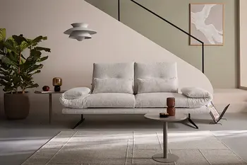 Minimalistisches Wohnzimmer mit beigem 2-Sitzer-Sofa, beigem Teppich und kleinem Beistelltisch.