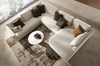 Design Ecksofa Contur Cuneo in beige dekoriert mit mehreren Kissen.