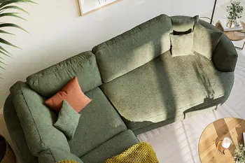 Vogelperspektive eines grünen Ecksofas mit geschwungenen Formen und abgerundeter Armlehne.