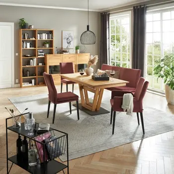 Heller Raum mit Massivholz Esstisch mit mehreren Stühlen und Massivholz Regal und Sideboard.