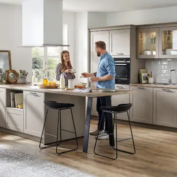 Ein Paar steht in einer beigefarbenen Küche im Landhausstil.&nbsp;