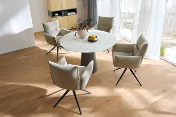 Runder Design Keramik Esstisch mit schwarzem Tischbein in einem hellen Raum. 