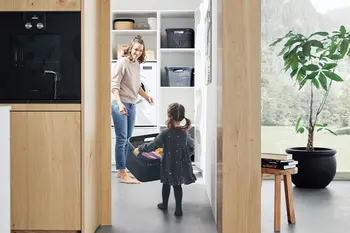 Kind hilft Mutter bei der Arbeit im Hauswirtschaftsraum