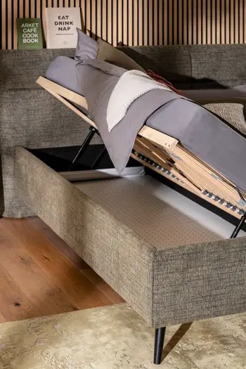 Polsterbett mit nach oben klappbarem Lattenrost, der Stauraum unterhalb der Matratze ermöglicht.