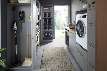 Ansicht eines schmalen Hauswirtschaftsraums mit verschiedenen Regalen und Schränken