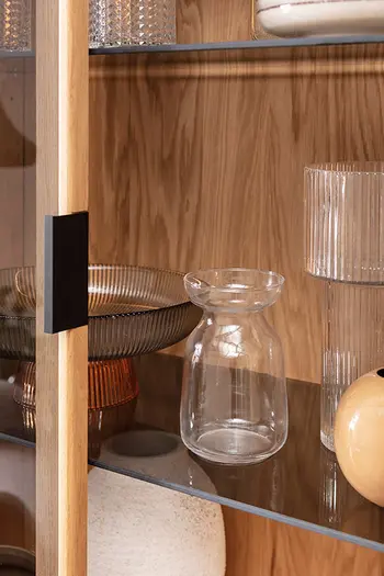 Detailbild von Regal mit Glaseinsätzen und Deko.