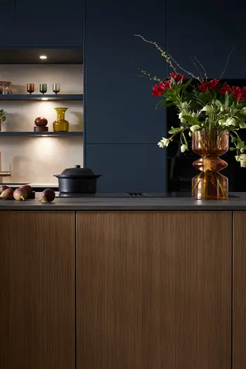 Nahansicht einer Küche mit blauen Hochschränken und brauner Lamellenfront an der Kücheninsel.