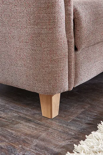 Holzfuß eines beigen Sofas.
