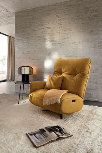 Gelber Leder Relaxsessel mit Armlehne auf der linken Seite und gelbem Kissen und Decke auf der Sitzfläche.