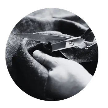 Stoff, den gerade jemand mit einer Schere zuschneidet.