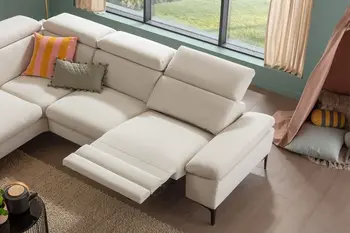 Beiges Ecksofa mit ausgeklappter Fußlehne und Kopfstütze.