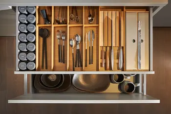 Geöffnete Schubladen einer grauen Küche.