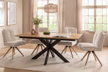 Esszimmer, eingerichtet in Beigetönen, mit großem Esstisch mit schwarzem Metallgestell und vier Polsterstühlen.