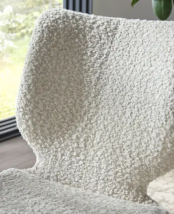 Detailbild von Rückenlehne eines modernen Esszimmerstuhls in weißem Bouclé-Stoff.