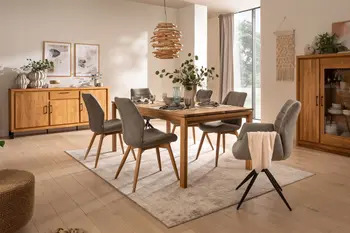 Helles Esszimmer mit Esstisch, Sideboard, Highboard aus dem gleichen hellen Holz mit modernen grauen Schalenstühlen und vielen Pflanzen und hellen natürlichen Dekoartikeln dekoriert.