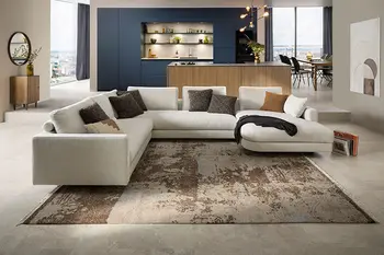 Hellbeiges Design Ecksofa vor einer Designküche mit Kücheninsel in Holzlook und blauen Hochschränken.