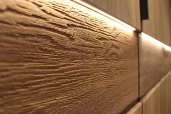 Nahaufnahme einer strukturierten Holzoberfläche mit integrierter LED-Beleuchtung in einem modernen Möbelstück.