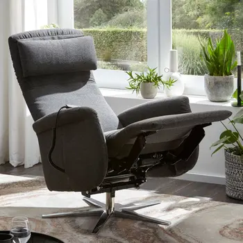 Grauer Relaxsessel mit nach hinten geklappter Rückenlehne und hochgeklappter Fußstütze.