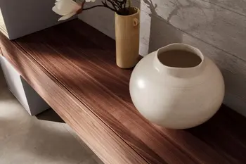 Hängendes Lowboard aus Nussbaum, an dem weiße Elemente angebracht sind.