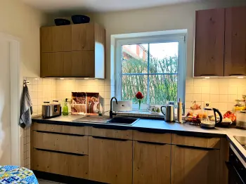 Eckküche mit Holzfront vor einem Fenster