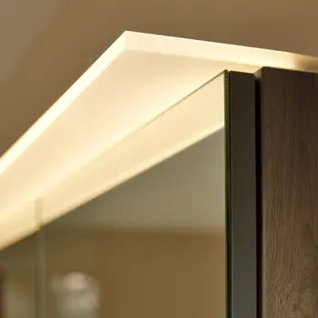 Detailaufnahme eines Wandspiegels mit intrigiertem Licht 