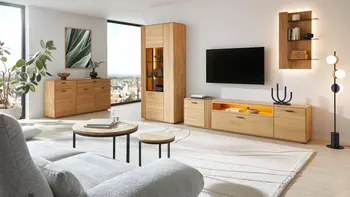 Helles Wohnzimmer mit moderner Wohnzimmerwand aus Eiche, beigem Teppich und hellgrauem Sofa. 