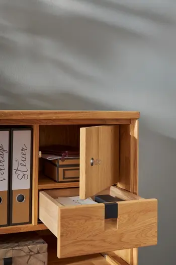 Geöffnete Schublade und verschließbares Fach eines Massivholz Sekretärs.