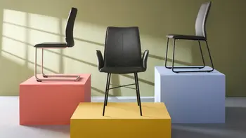 Modernes Zimmer mit drei Freischwinger Stühlen die auf bunten Blöcken dekorativ platziert sind. 