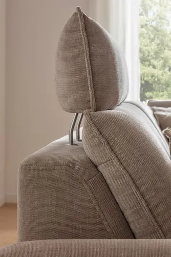 Seitliche Aufnahme einer Kopflehne eines beigen Sofas.