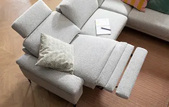 Verstellbare Relaxfunktion einer grauen Eckcouch mit ausgezogener Fußstütze und verstellbarer Rückenlehne – komfortables, modernes Sofa mit ergonomischen Funktionen für entspanntes Sitzen und Liegen im Wohnzimmer.