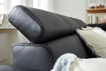 Klappbare Kopfstütze eines schwarzen Ledersofas.