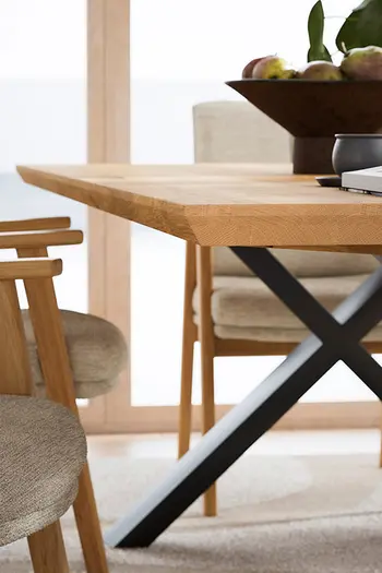 Schweizer Tischkante eines Esstischs mit Tischplatte aus Wildeiche mit schwarzem Metallgestell.