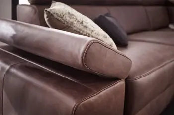 Klappbare Armlehne eines braunen Ledersofas.