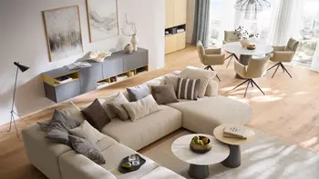 Modernes Apartement mit offenem Wohnbereich und beiger Wohnlandschaft und Essbereich mit rundem Esstisch und beigen Armlehnstühlen.