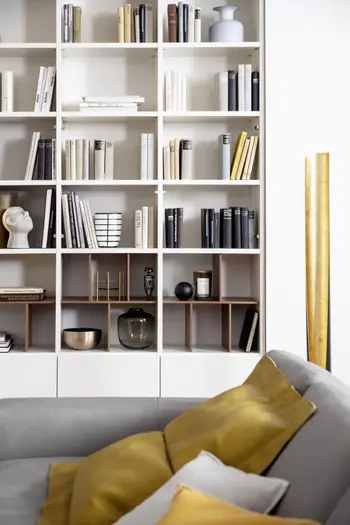 Moderne weiße Regalwand befüllt mit Büchern und Deko.