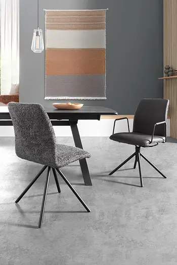 Zwei Esszimmerstühle in Grau stehen sich an Esstisch gegenüber.