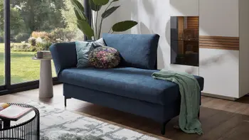 Blaue Polsterliege mit Schlaffunktion in einem hellen Raum.