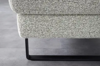 Schwarze Kufe eines beigemelierten Sofas.