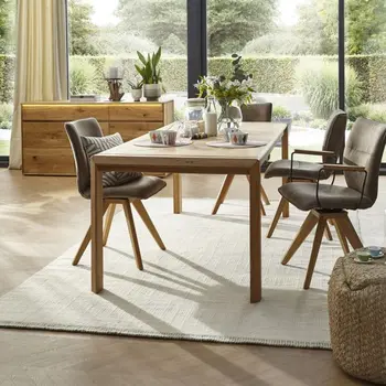 Beleuchtetes Sideboard in einem modernen Esszimmer mit Massivholzesstisch und Schalenstühlen.