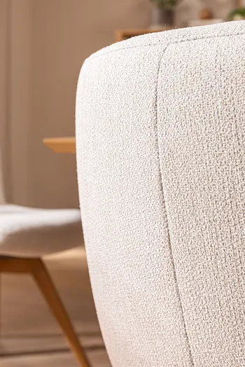 Detailbild der Naht einer Rückenlehne von Esszimmerstuhl mit beigem Stoffbezug.