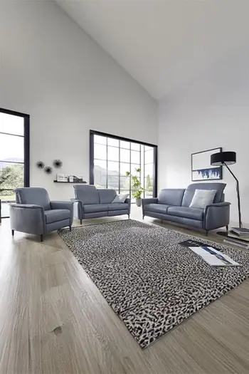 Zwei blaue Ledersofa Garnituren mit verstellbarer Kopfstütze und einem dazu passenden Sessel.