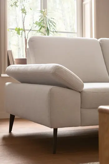 Hellbeiges Sofa mit klappbarer Armlehne und schwarzen Füßen.