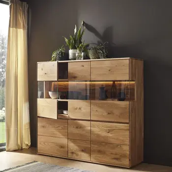 Beleuchtetes Highboard aus Massivholz, auf dem viele Pflanzen stehen.